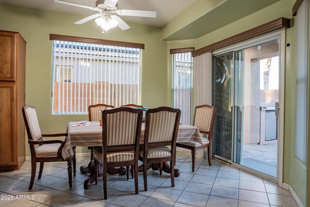 dining room with baseboards, light tile patterned floors, and a ceiling fan