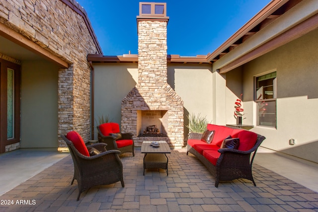 view of patio with an outdoor living space with a fireplace