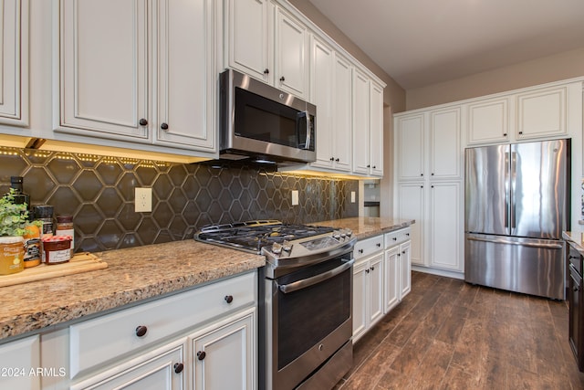 kitchen featuring white cabinetry, stainless steel appliances, light stone countertops, and dark hardwood / wood-style flooring