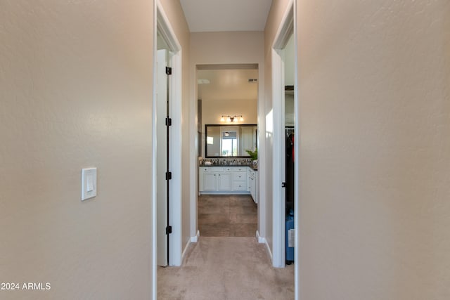 corridor featuring light colored carpet