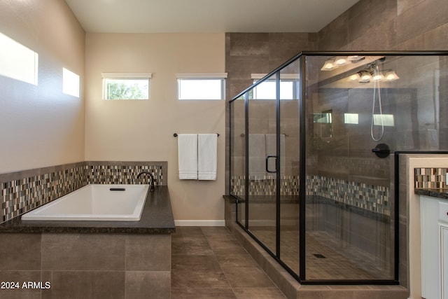 bathroom with vanity and shower with separate bathtub