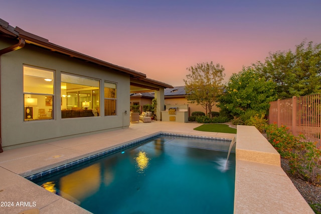 pool at dusk featuring a patio area and pool water feature