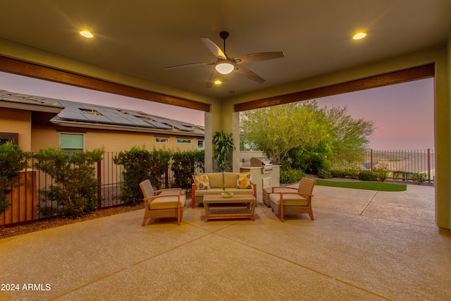 patio terrace at dusk featuring ceiling fan and an outdoor hangout area