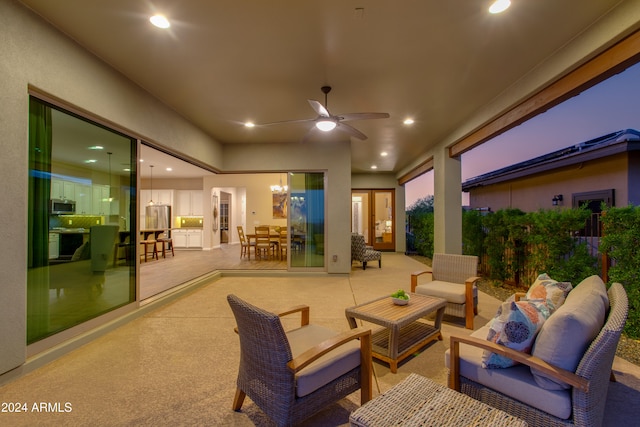 patio terrace at dusk with outdoor lounge area and ceiling fan