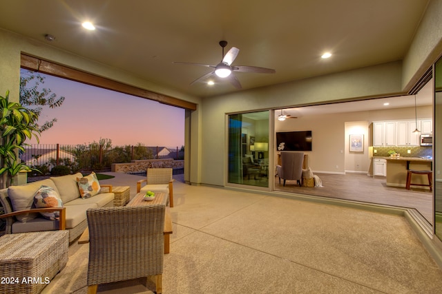 patio terrace at dusk featuring an outdoor living space and ceiling fan