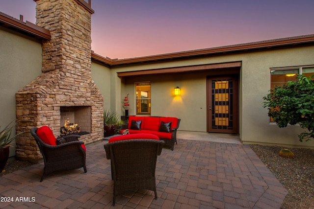 patio terrace at dusk with an outdoor living space with a fireplace