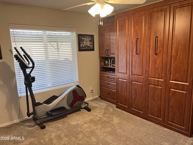 workout room with baseboards, ceiling fan, and carpet flooring