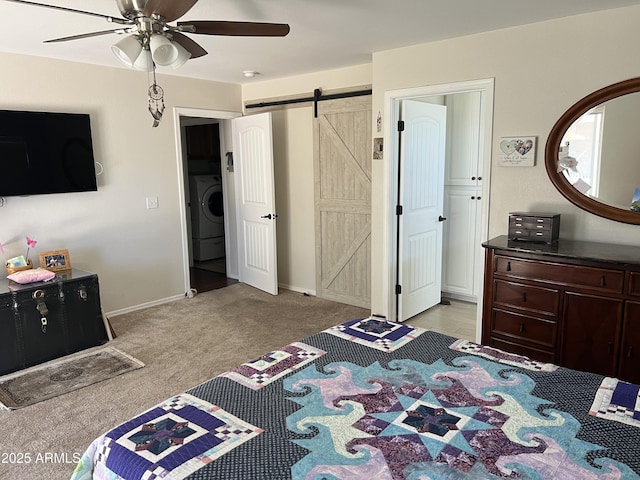 bedroom with baseboards, a barn door, light carpet, washer / dryer, and a ceiling fan