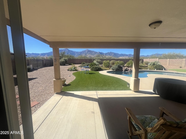 view of patio with a mountain view, a fenced in pool, and a fenced backyard