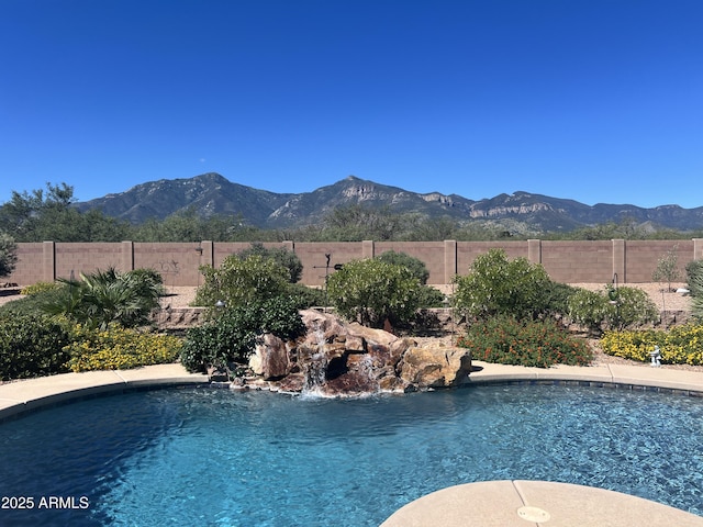 view of swimming pool featuring a fenced in pool, a fenced backyard, and a mountain view