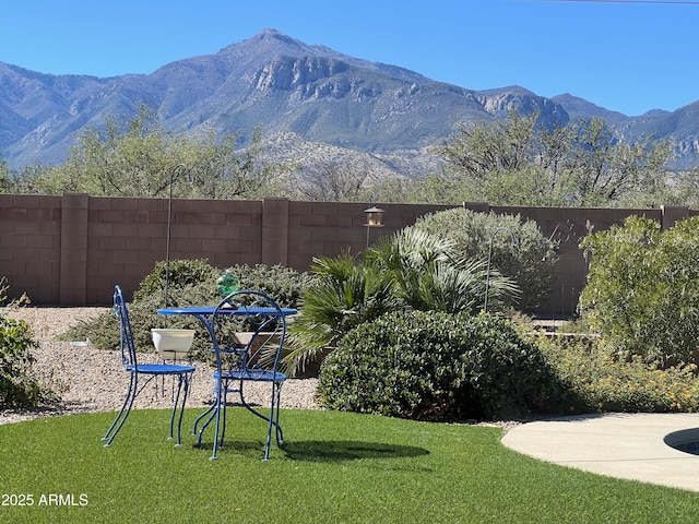 view of yard featuring a mountain view and fence