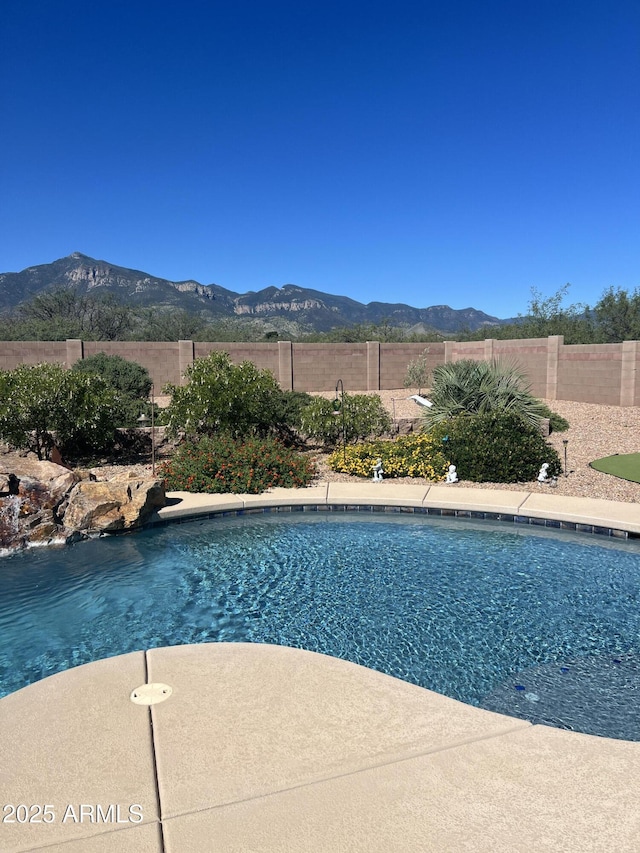 view of pool featuring a patio area, a fenced in pool, a mountain view, and a fenced backyard