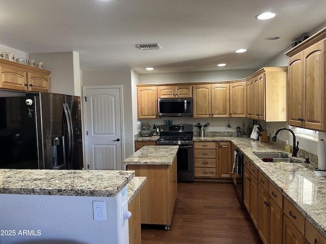 kitchen featuring visible vents, black appliances, a sink, dark wood-style floors, and a center island