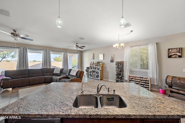 kitchen with visible vents, a sink, open floor plan, and ceiling fan with notable chandelier
