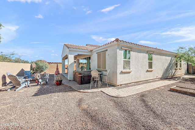 back of property featuring a patio, a fenced backyard, stucco siding, and a tiled roof