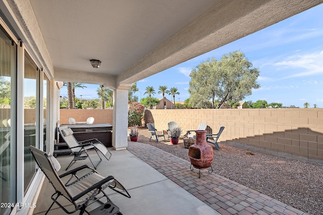 view of patio featuring a hot tub and a fenced backyard