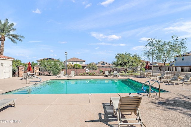 community pool featuring fence and a patio area
