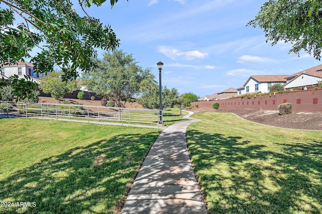 surrounding community with fence and a yard