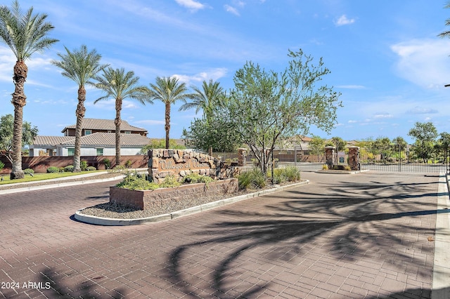 view of road with curbs, a gated entry, and a gate