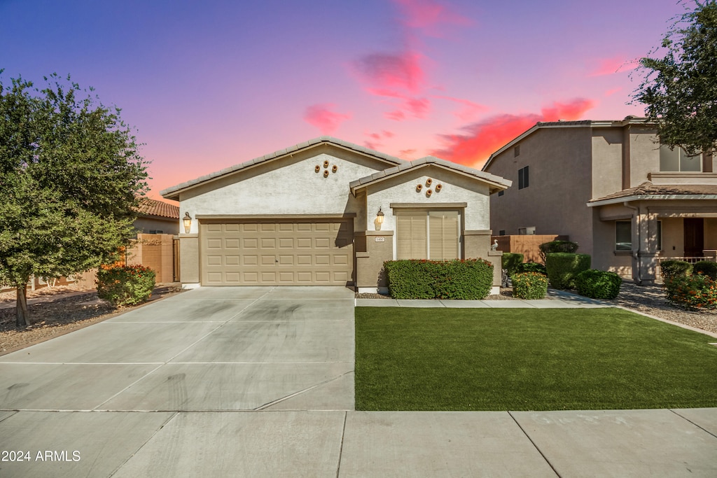 view of front of house with a yard and a garage