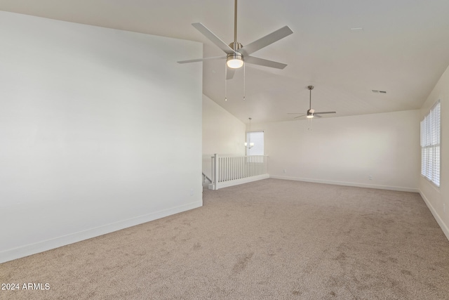 carpeted empty room featuring ceiling fan, a healthy amount of sunlight, and vaulted ceiling