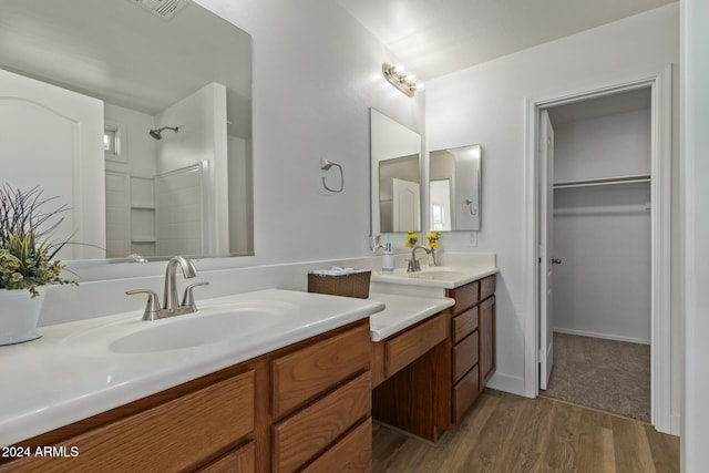 bathroom featuring vanity, wood-type flooring, and walk in shower