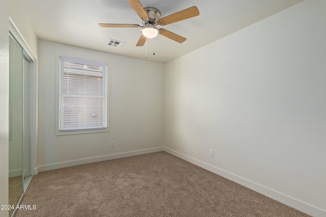 carpeted spare room with ceiling fan