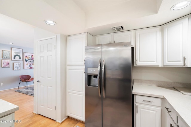 kitchen with white cabinets, stainless steel refrigerator with ice dispenser, and light hardwood / wood-style floors