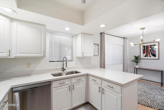 kitchen featuring stainless steel dishwasher, decorative light fixtures, white cabinets, and sink