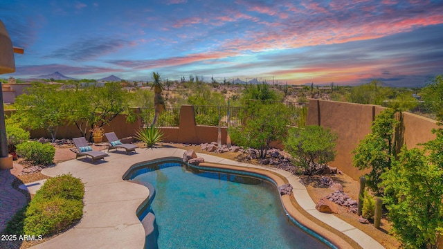 8154 E Tecolote Cir, Scottsdale, AZ 85266 - pool at dusk with a fenced backyard, a patio, and a mountain view