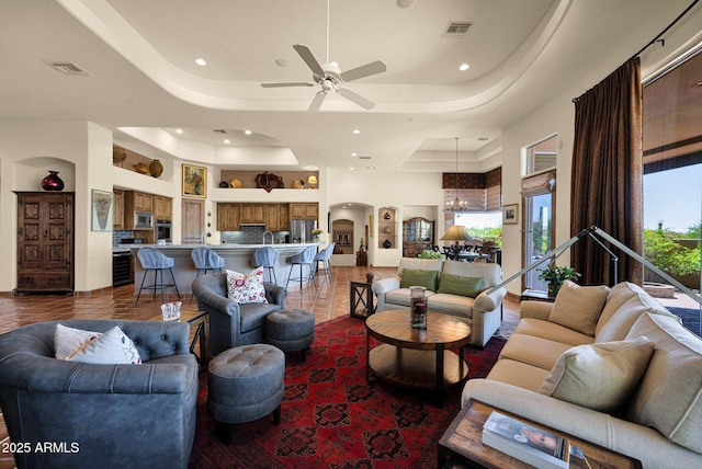 8154 E Tecolote Cir, Scottsdale, AZ 85266 - living area featuring a tray ceiling, arched walkways, ceiling fan, and recessed lighting