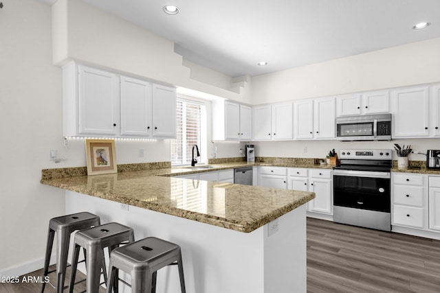 12852 N Mountainside Dr Unit 2, Fountain Hills, AZ 85268 - kitchen featuring appliances with stainless steel finishes, a kitchen bar, white cabinets, a peninsula, and recessed lighting