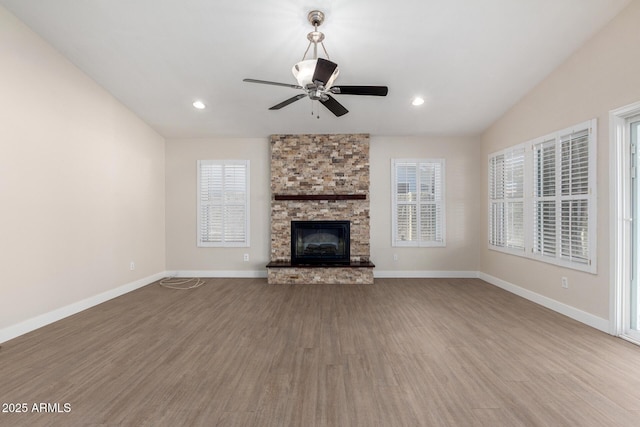 unfurnished living room featuring ceiling fan, a fireplace, wood-type flooring, and lofted ceiling