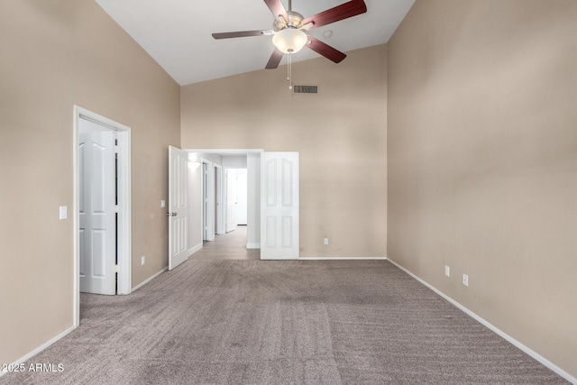 spare room with ceiling fan, light carpet, and high vaulted ceiling