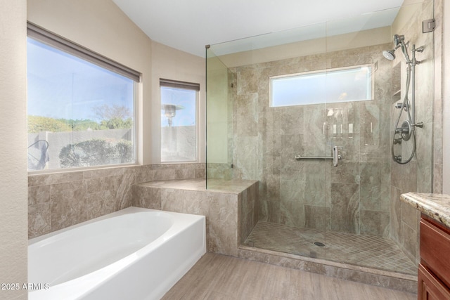 bathroom featuring hardwood / wood-style flooring, vanity, and separate shower and tub