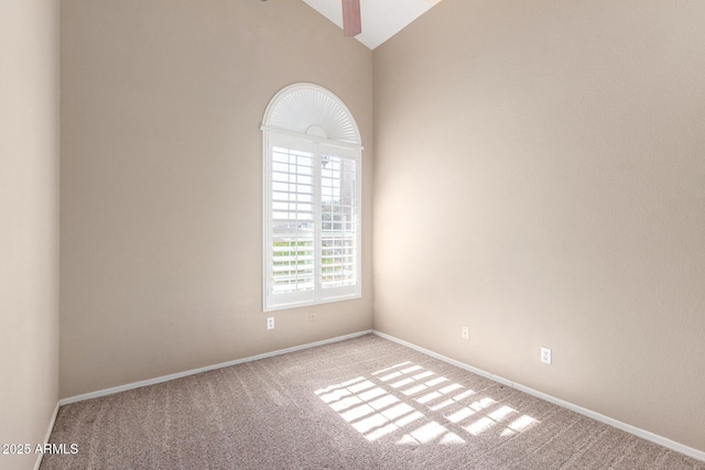 unfurnished room with carpet and high vaulted ceiling