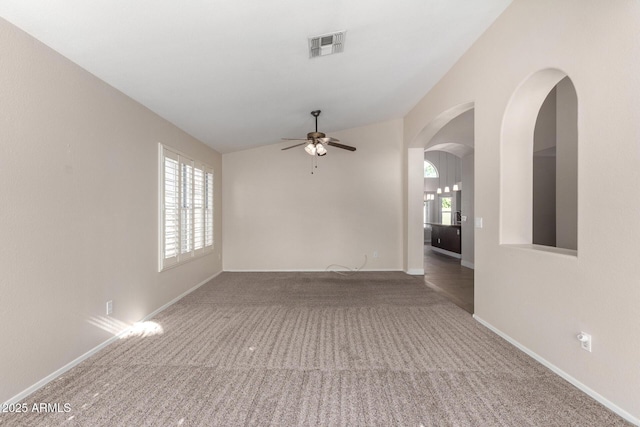 carpeted spare room with ceiling fan and vaulted ceiling