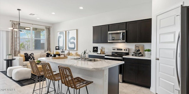 5549 E Mearn Rd, San Tan Valley, AZ 85140 - kitchen featuring appliances with stainless steel finishes, a sink, light tile patterned flooring, a breakfast bar area, and light stone counters