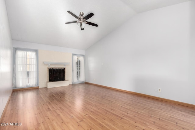 unfurnished living room with ceiling fan, light hardwood / wood-style floors, lofted ceiling, and a brick fireplace