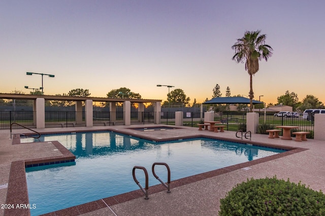 pool at dusk featuring a patio area