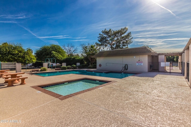 view of pool with a patio area and a hot tub