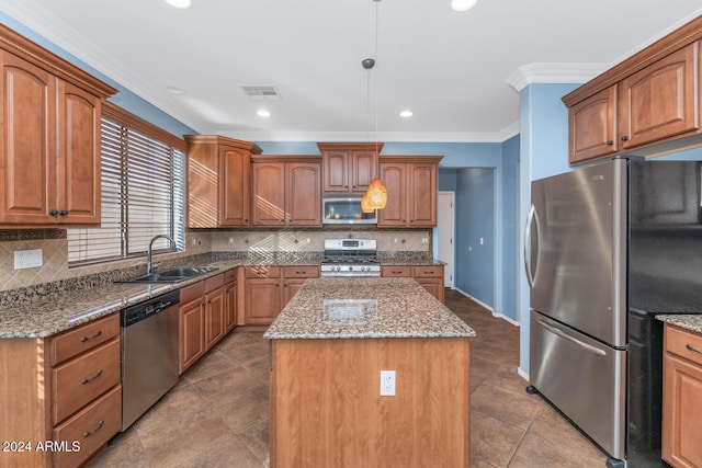 kitchen featuring sink, backsplash, decorative light fixtures, a kitchen island, and appliances with stainless steel finishes