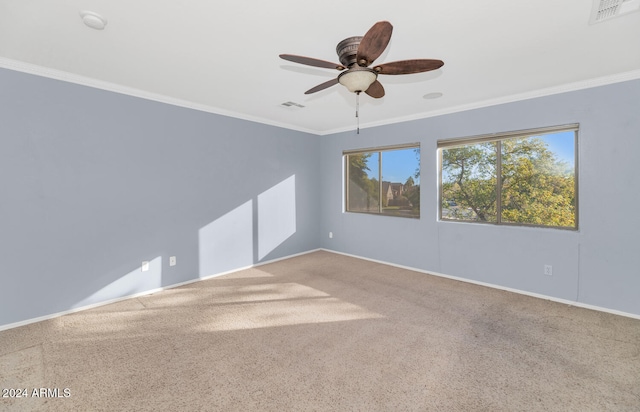 empty room featuring carpet flooring, crown molding, and ceiling fan