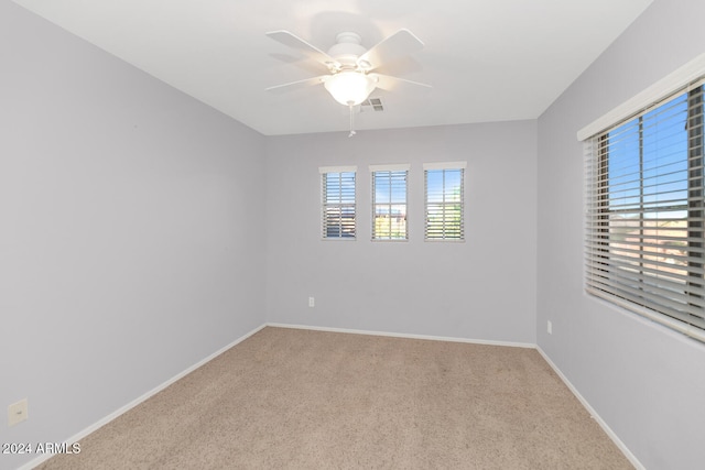 carpeted empty room featuring plenty of natural light and ceiling fan