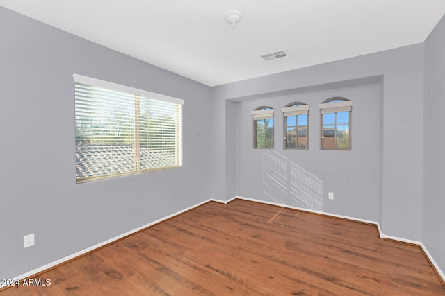 unfurnished room with hardwood / wood-style flooring