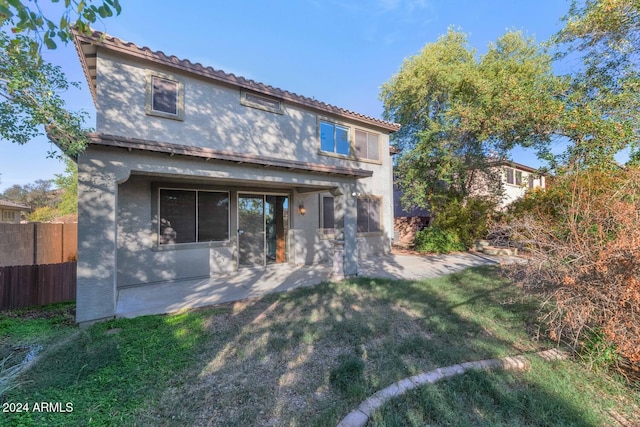 rear view of house featuring a patio and a lawn