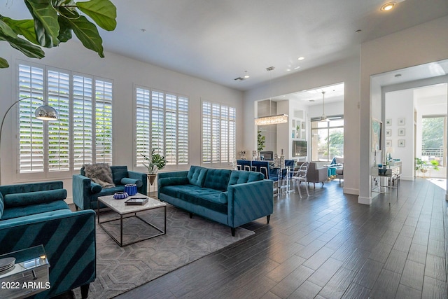 living room with dark wood-style flooring, baseboards, and recessed lighting