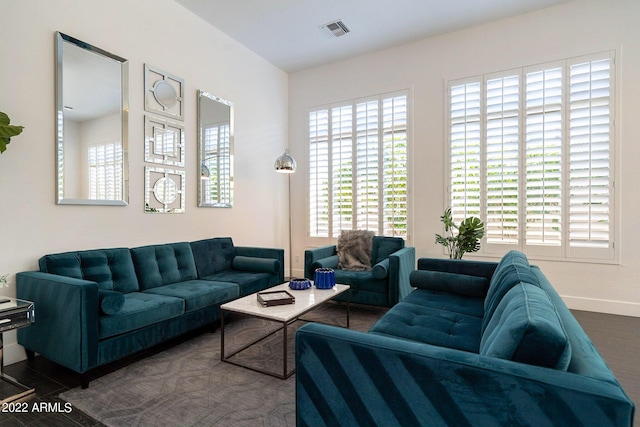 living area with wood finished floors, baseboards, and visible vents