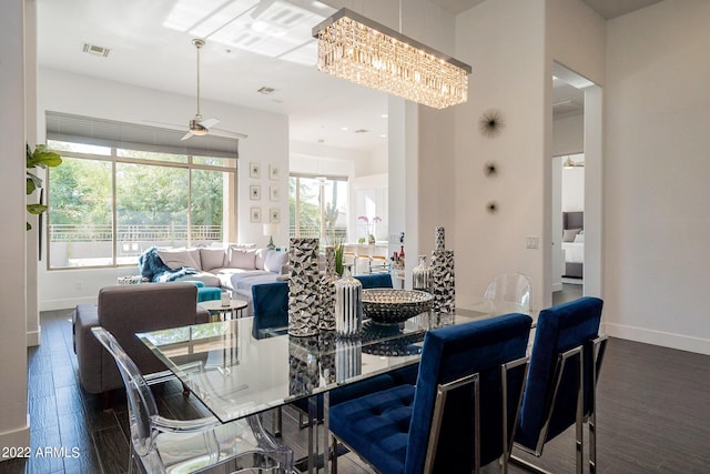 dining area with baseboards, visible vents, ceiling fan with notable chandelier, and dark wood-style flooring