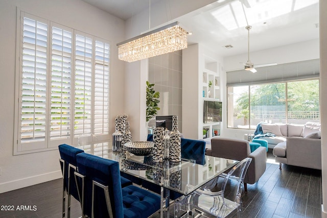 dining area featuring baseboards, visible vents, wood finished floors, and ceiling fan with notable chandelier